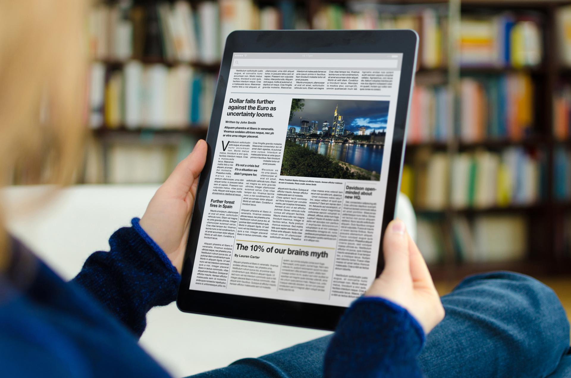 Artikler om AI, ledelse og digital transformation Kvinde læser artikler om AI i virksomheden og digital transformation på tablet